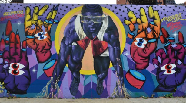 mural of a black man in the stance held at the beginning of a running race, 
