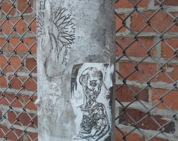 paper pasteup on a metal pole, sad man