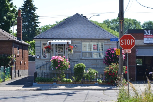 small bungalow with small porch and flowers on the porch 