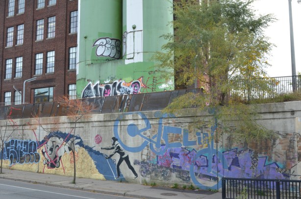 part of a mural, strength in numbers, on the concrete walls of an underpass