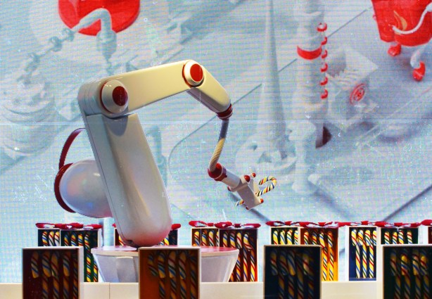 a shiny white robotic arm packages candy canes into boxes, an h b c window display, striped candy canes, 