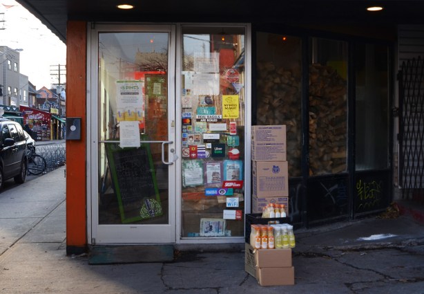 boxes of juice sitting outside a store that hasn't opened yet. 