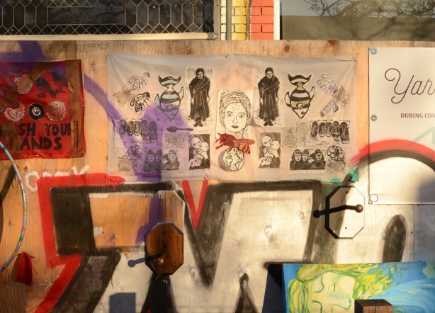 pictures on a plywood fence outside, graffiti 