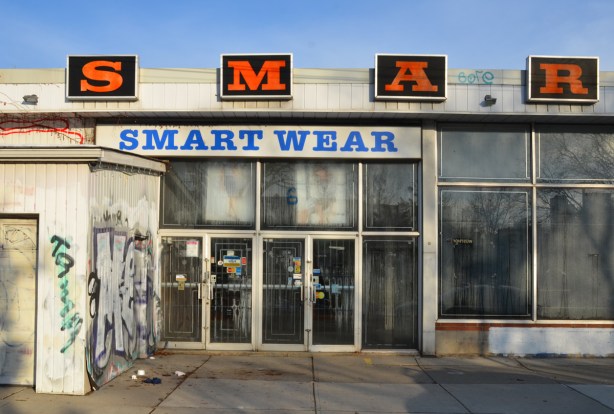 front of old smartwear store, now closed and empty, very dirty glass on windows and doors 
