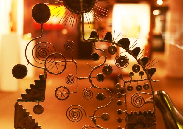 metal sculpture in a window, made with metal wire, many spiral shapes