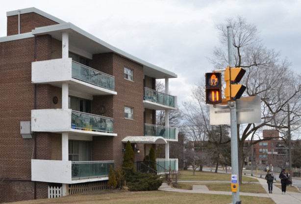 three storey red brick apartment building on the corner of Don Mills and the Donway with traffic light