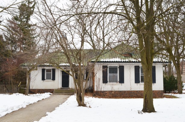 old bungalow house on Glendon college campus, winter, green tile roof, white walls, black shutters, 