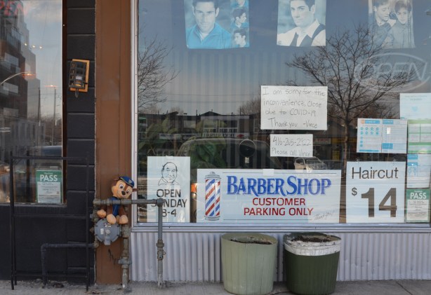 storefront on kingston Road in Cliffside, barber shop, closed because of covid, faded pictures of mens heads show casing hair styles in the window, 