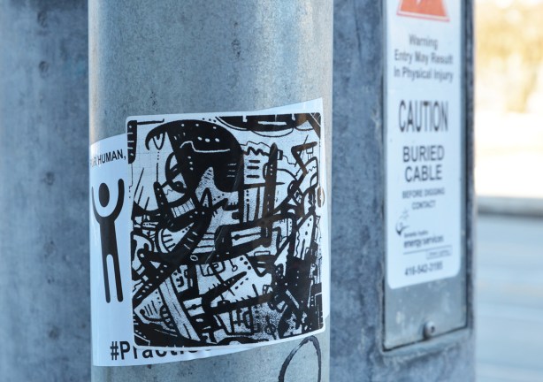 black and white sticker graffiti on a pole