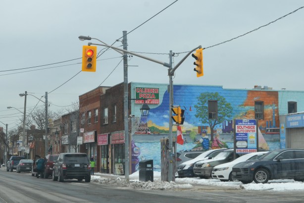 mural on the side of a two storey brick store on Lakeshore in Mimico, sign says Calibreze Pizza. 