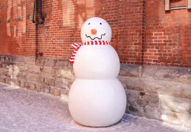 tall fake snowman with a red and white striped scarf, in the distillery district