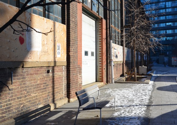 bench on sidewalk in front of old foundry building 