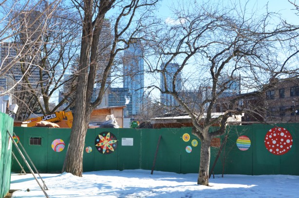 green plywood hoardings around Crosstown construction, with artwork on them, painted designs on wood 