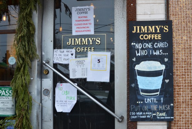 signs on the door of Jimmys coffee shop, wear a mask, wear it right, and other covid notices 
