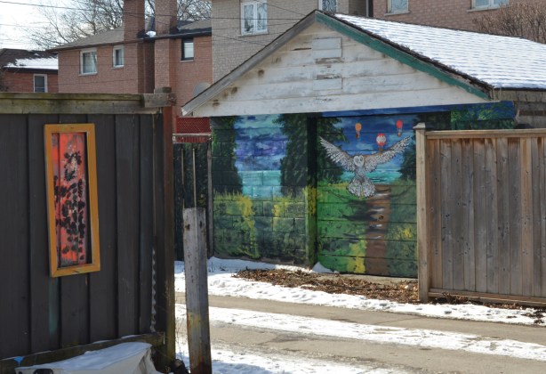 double car garage in an alley with murals painted on them, owl theme, 