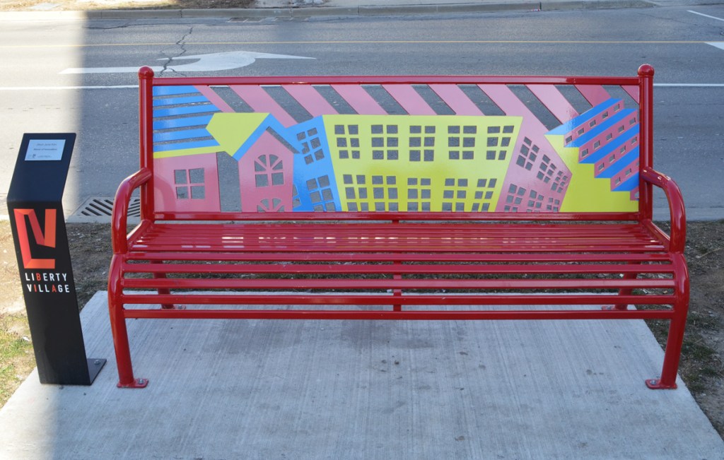 a bench in Liberty Village with the back piece decorated in houses in primary colours