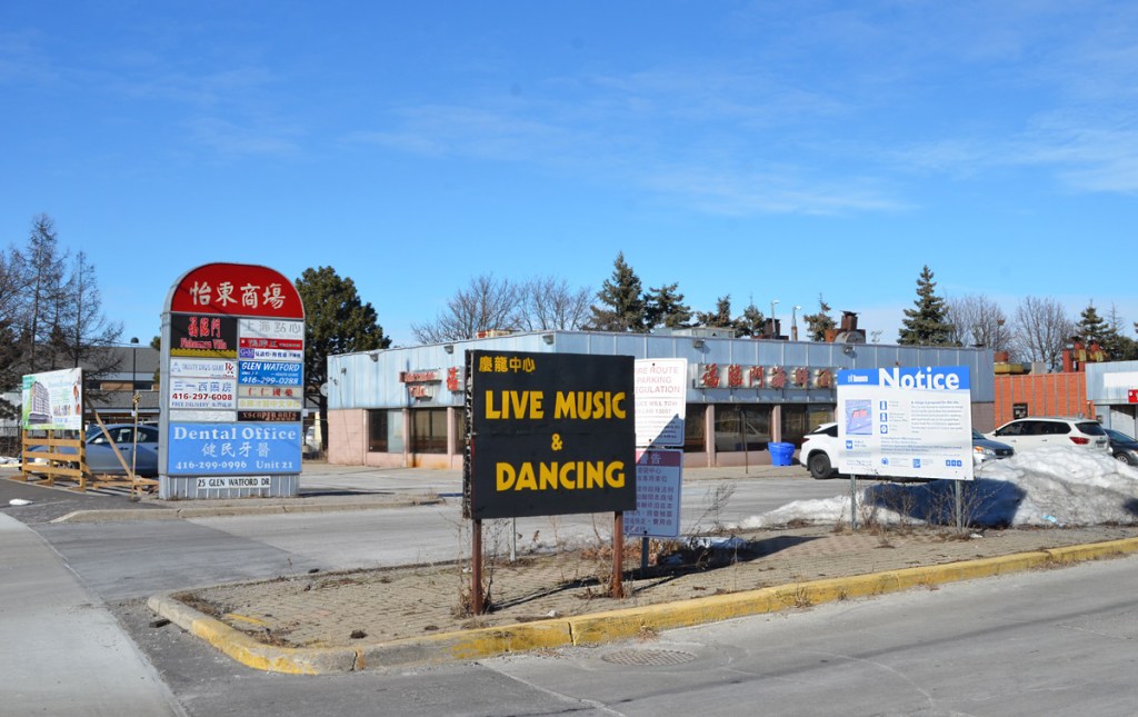 sign advertising live music and dancing in front of a strip mall that is about to be redeveloped