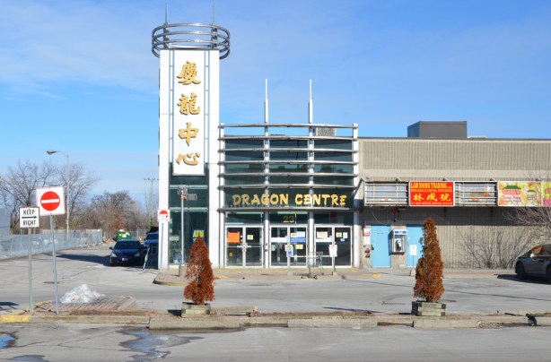 Dragon centre, Chinese market, now closed and empty, empty parking lot and two small dead cedar trees