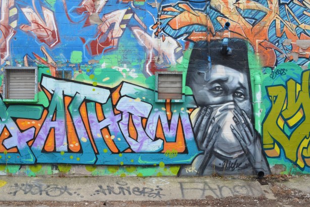 mans face, with hands holding a mask over his mouth and nose, painted by elicser in a doorway