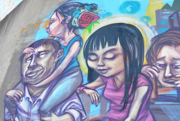 part of an elicser mural, a woman with a red rose in her hair sits on a man's shoulders, a woman in a pink dress is also in the picture 