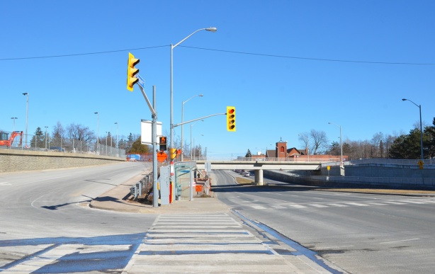 sheppard avenue east just east of kennedy road, with GO train bridge overpass, all concrete, with access road to Go station on the left 