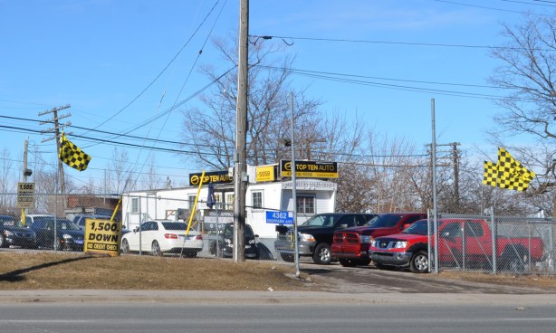 Top ten auto, used car sales, white trailer, yellow and black checkered flags 