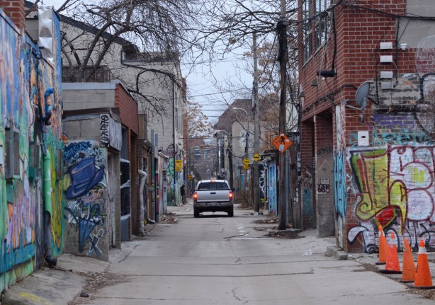 a pickup truck drives down an alley