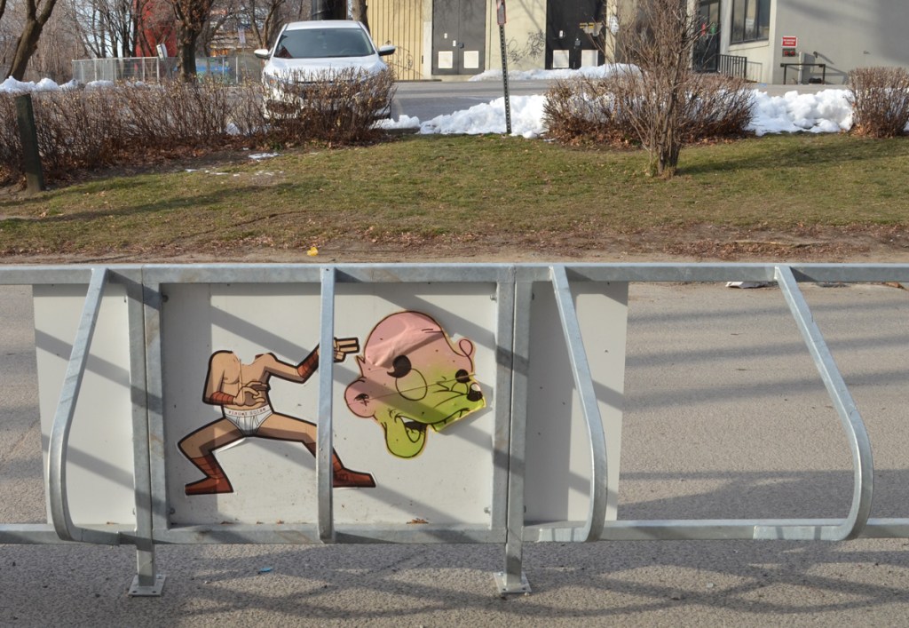 metal bicycle rack with a large paste up of urban ninja squadron t bonez wearing white briefs and nothing else, also no head 