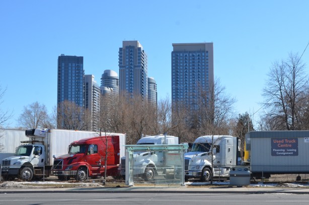 looking across the street to a used truck lot, tall condos in the background