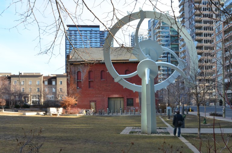 a large white metal sculpture in a park in Liberty village 
