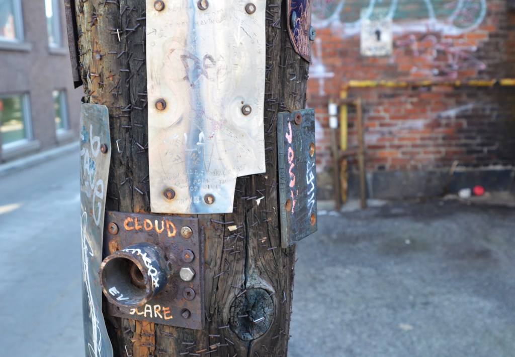 some metal pieces that are graffiti on a pole