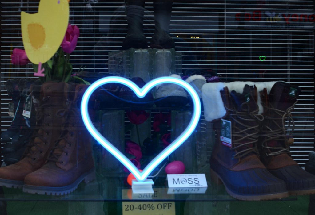 blue LED lights in the shape of a heart in the window of a shoe store on Queen Street East