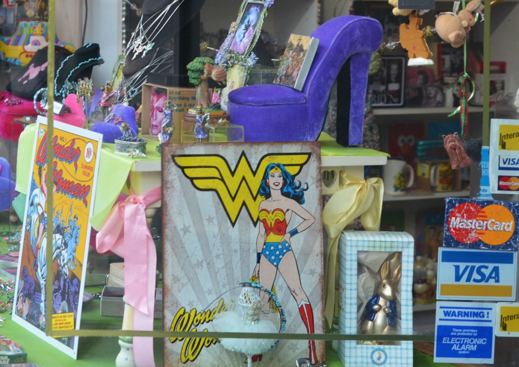 store window, wonder woman items, a large purple platform shoe, 