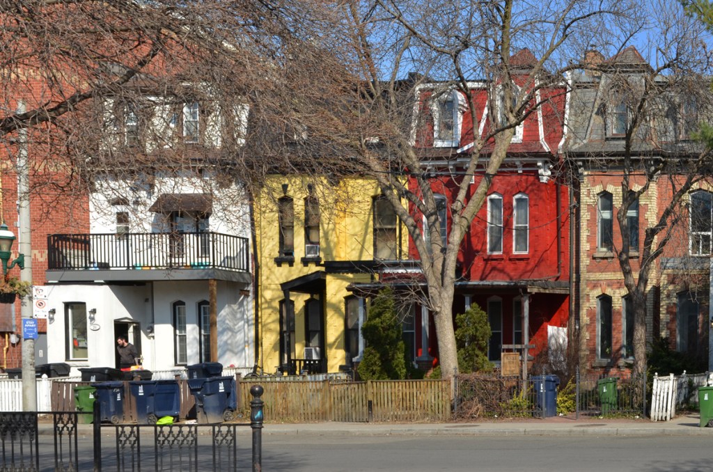 old heritage row houses - one white, then yellow, then bright red, then red brick