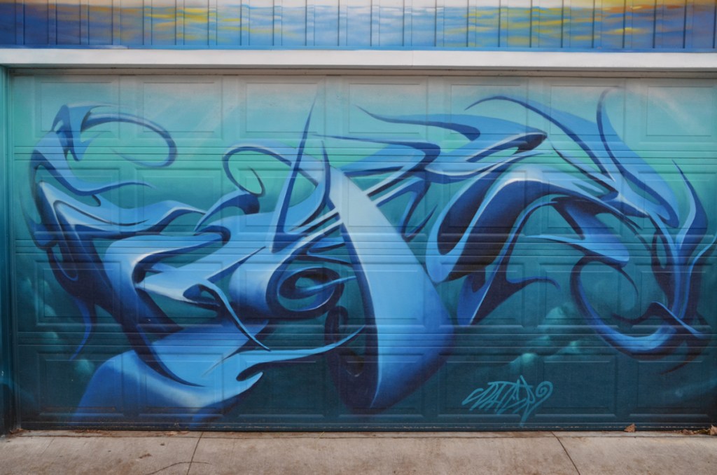 part of a mural, text graffiti, very three dimensional looking in shades of blue on blue background, representing water 