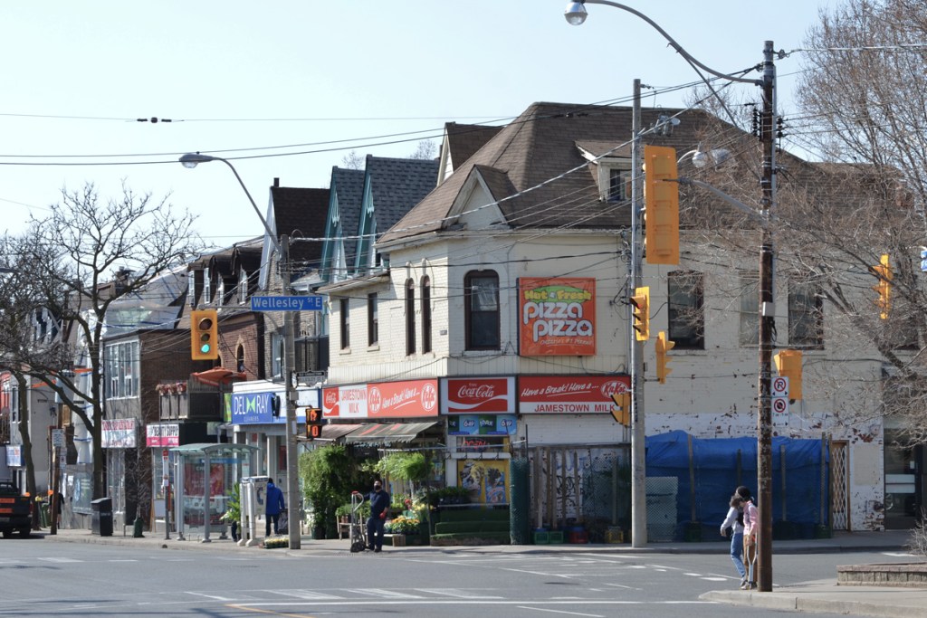 southwest corner of Parliament and Wellesley with Pizza Pizza ad on the corner above Jamestown Milk convenience store