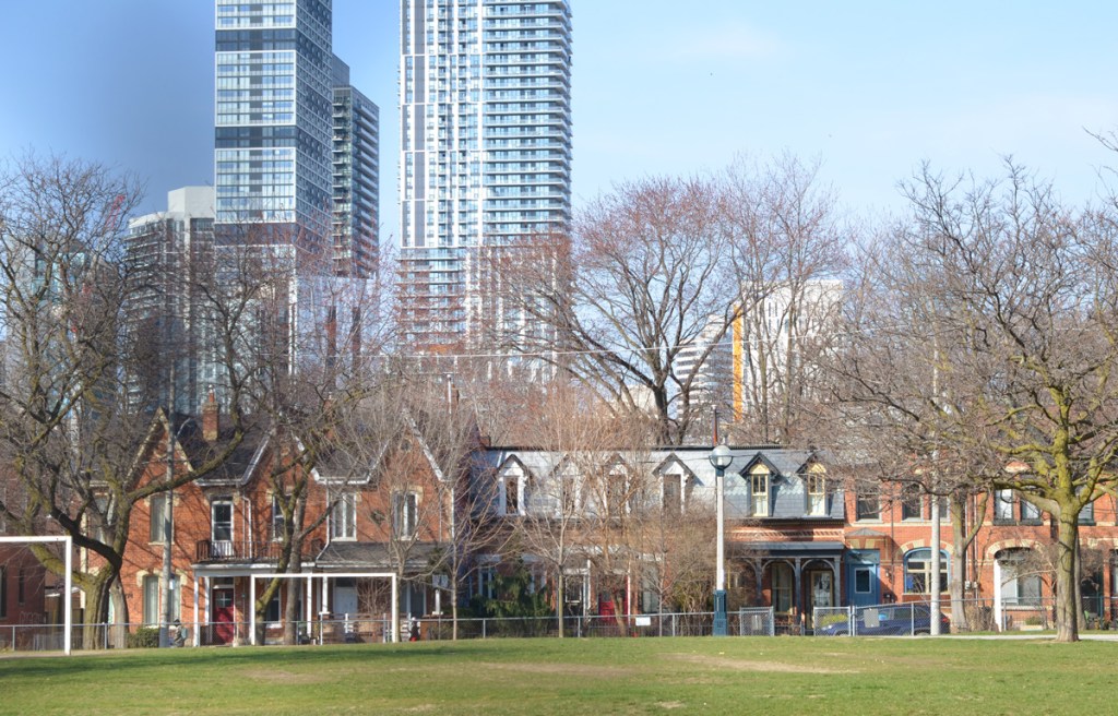 old two storey brick rowhouses on Berkeley Street, across from Lord Dufferin public school.  Victorian houses, with tall glass and steel condo towers behind them