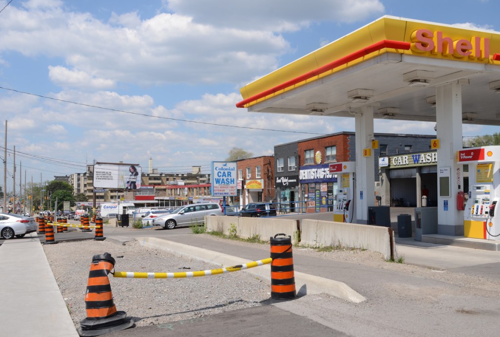 Shell service station, gas station, and other businesses on the north side of Eglinton including a car wash, a dentist office, two storey development