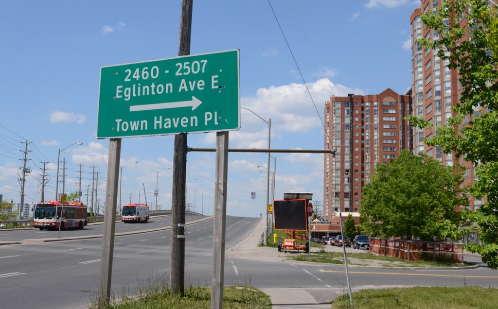apartment buildings on north side of Eglinton, Town Haven place and traffic sign directions to parts of Eglinton not on the hill bridge