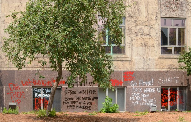 place where statue of Egerton Ryerson once stood, a single tree, graffiti on the walls of the building