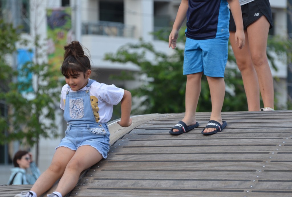 kids playing on the Simcoe Wave Deck, a young girl is sliding down it