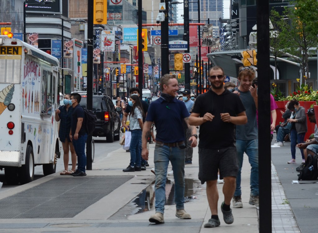 an Asian couple at the ice cream truck, men walking on the sidewalk, Yonge street at Dundas