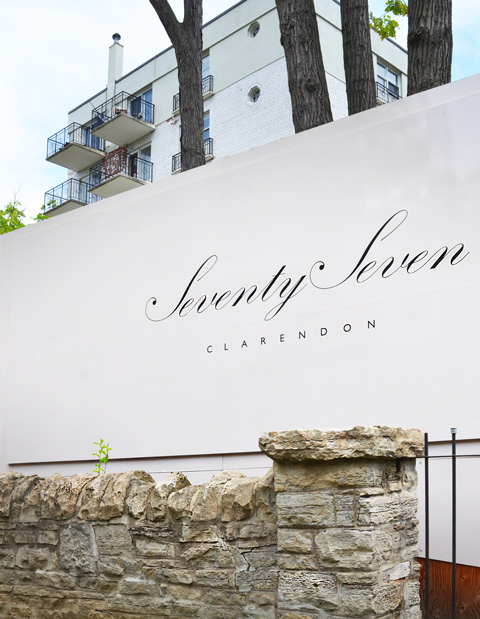 construction hoardings in front of a low rise apartment building at 77 Clarendon