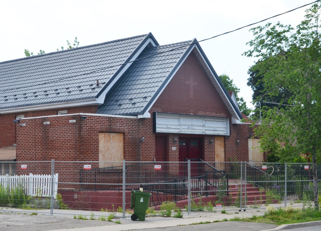 old red brick church at 587 Oakwood, windows boarded up and cross removed from over front door 