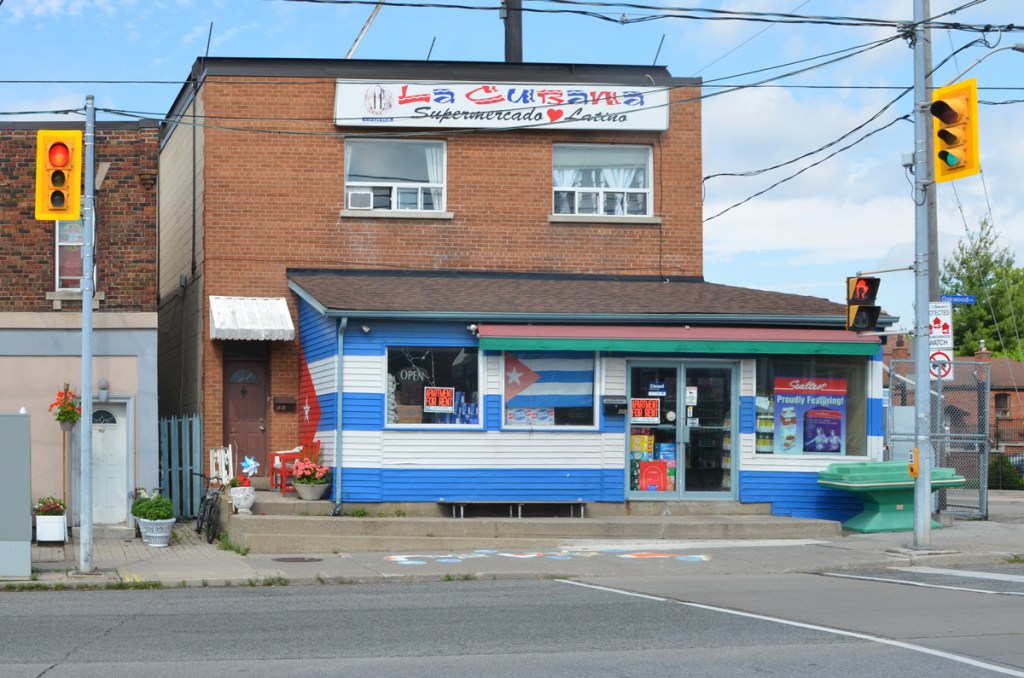 La Cubana supermercado Latino, grocery store, first storey painted in blue and white stripes like the Cuban flag,  Cuban flag hanging in the window 