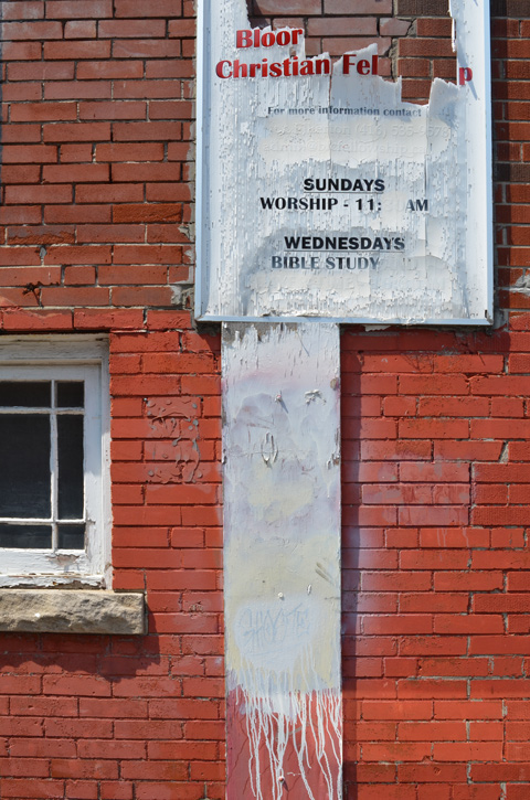 weathered sign beside Baptist church 