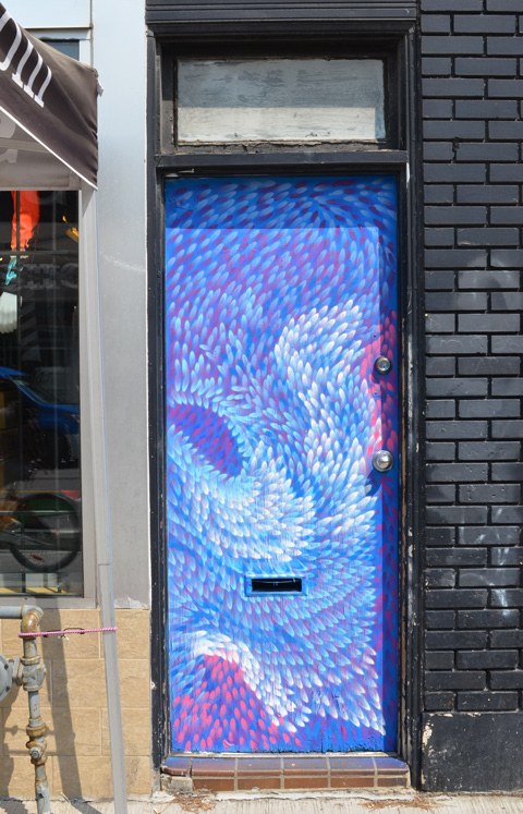 a door on Bloor Street painted in pink, blue, and white dabs
