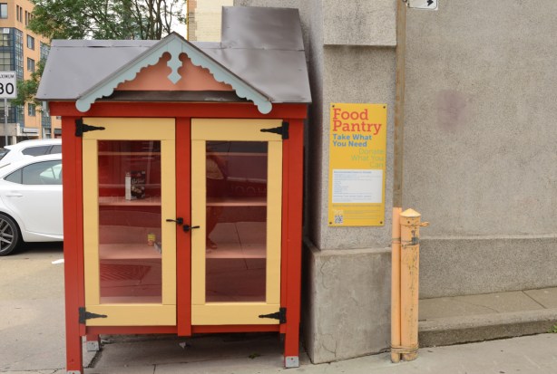 Free food pantry, shelves with glass covered doors for food to exchange, it is almost empty 