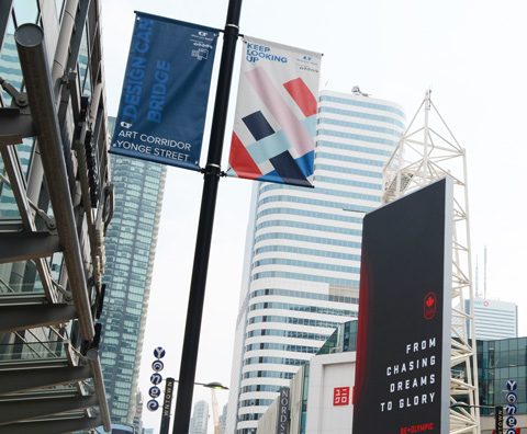 Yonge Street, looking up at banners on metal poles, tops of some highrise buildings, 