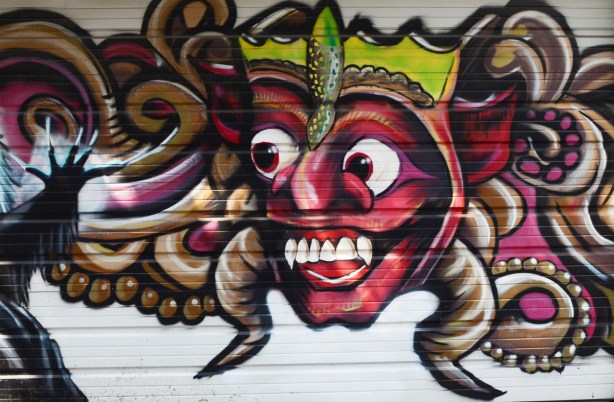 big red faced, apple?, character, street art on a garage door